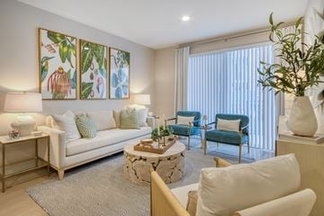 Naples apartment for rent - A living room with a white couch, a coffee table, and a painting on the wall.