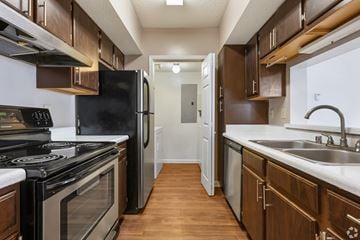 Birmingham apartment for rent - A kitchen with a black stove top oven and a black refrigerator.