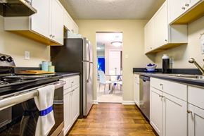 Savannah apartment for rent - A kitchen with a black refrigerator and white cabinets.