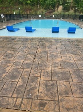 Fultondale apartment for rent - A pool surrounded by blue chairs and a black fence.