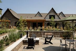 Charlotte apartment for rent - A patio with a table and chairs is in front of a house.