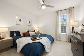 Charlotte apartment for rent - A bedroom with a blue bedspread and a white blanket on the bed.