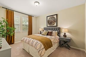 Baton Rouge apartment for rent - A bedroom with a large bed and a potted plant.