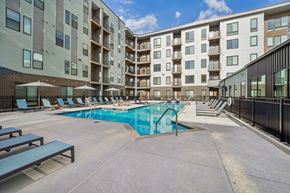 Birmingham apartment for rent - A swimming pool surrounded by apartment buildings and lounge chairs.