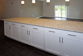Portage apartment for rent - oversized breakfast bar with cabinets, pendant lighting, and granite countertop EV charging stations at Promenade at Founders Square Apartments in Indianapolis, IN