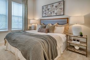 Erlanger apartment for rent - A bedroom with a large bed and a painting above it.