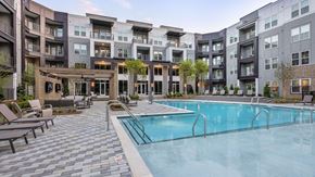 Erlanger apartment for rent - A large swimming pool surrounded by lounge chairs and apartment buildings.