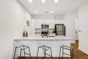 Indianapolis apartment for rent - A kitchen with white cabinets and a marble countertop.