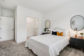 Indianapolis apartment for rent - A bedroom with a large bed, a dresser, and a mirror.