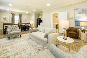 Tuscaloosa apartment for rent - A well-lit living room with a grey sofa and a wooden floor.