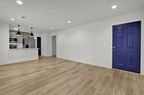 Birmingham apartment for rent - an empty living room with a blue door and a kitchen