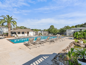Mobile apartment for rent - A pool area with chairs and a palm tree.