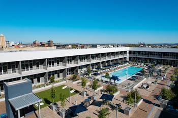 An aerial view of a hotel with a swimming pool and patio furniture