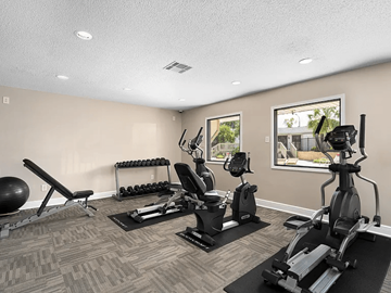 Mobile apartment for rent - A home gym with a variety of equipment including a treadmill, exercise bike, and weights.