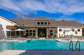Fairhope apartment for rent - A large swimming pool in front of a house with a white exterior.