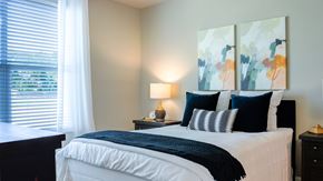 Fairhope apartment for rent - A bedroom with a large bed and a painting on the wall.