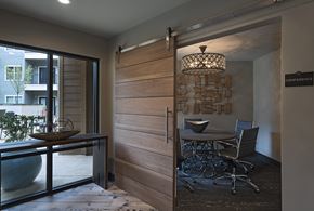 Jackson apartment for rent - A conference room with a wooden door and a glass table with chairs.