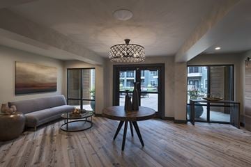 Jackson apartment for rent - A modern living room with a grey couch, a wooden coffee table, and a large painting on the wall.