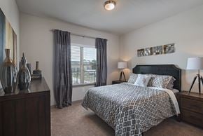 Jackson apartment for rent - A bedroom with a large bed and a nightstand with a lamp.