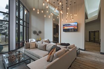 Two-story open-air resident lounge with seating, flat-screen tvs and gaming tables