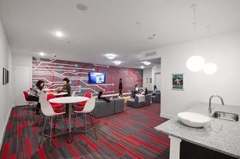 A lounge area with tables and chairs and a tv