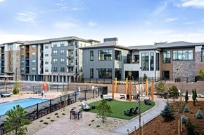 Broomfield apartment for rent - A modern apartment complex with a pool and outdoor seating area.