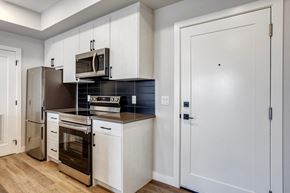 Edmonton apartment for rent - A kitchen with white cabinets and a black countertop.