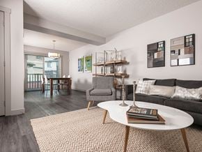 Edmonton townhouse for rent - A living room with a grey couch, a white coffee table, and a grey armchair.