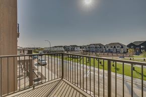 Calgary townhouse for rent - A balcony overlooks a street with cars and houses.