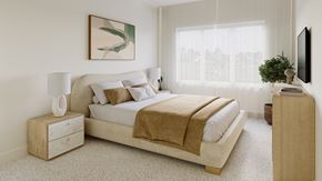 Calgary townhouse for rent - A bedroom with a large bed and a nightstand with a lamp.
