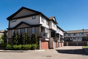 Edmonton townhouse for rent - A large, modern two-story residential building with a parking lot in front.