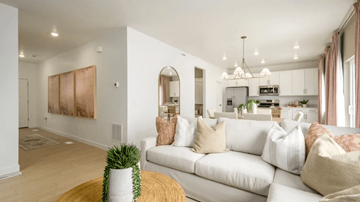Saratoga Springs apartment for rent - A living room with a white couch and a potted plant on a yellow rug.