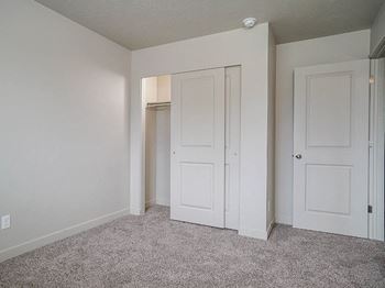 Spare bedroom with dual closets and neutral carpet