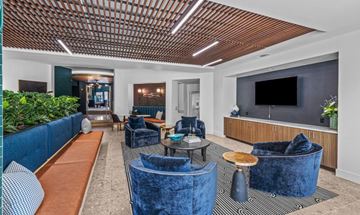 Dallas apartment for rent - A living room with blue velvet chairs and a wooden ceiling.