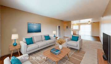 La Mesa apartment for rent - A living room with a white couch, a blue pillow, a wooden coffee table, and a painting on the wall.