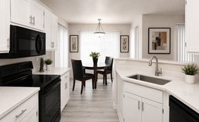 Phoenix apartment for rent - A black and white kitchen with a table and chairs.
