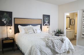 Peoria apartment for rent - A bedroom with a large bed and two lamps on side tables.