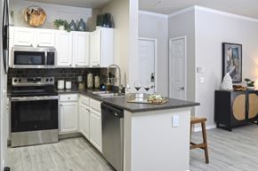 Peoria apartment for rent - A kitchen with white cabinets and a black countertop.