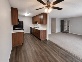 El Cajon apartment for rent - A kitchen with wooden cabinets and a black fridge.