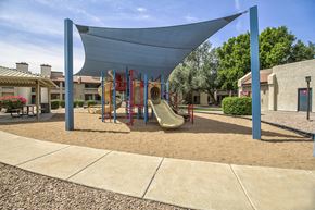 Mesa apartment for rent - a playground with a swing set and slides in a courtyard