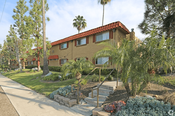 Santee apartment for rent - A house with a red tile roof is surrounded by green plants and trees.