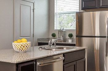 Kitchen sink area with granite countertop and window