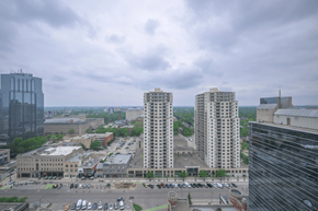 London apartment for rent - A cityscape with a mix of modern and older buildings, a parking lot, and a cloudy sky.