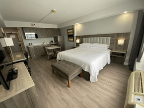 London apartment for rent - A bedroom with a bed, nightstand, and a small kitchenette.