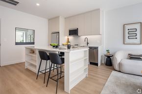 Montreal apartment for rent - A modern kitchen with white cabinets and a large island.