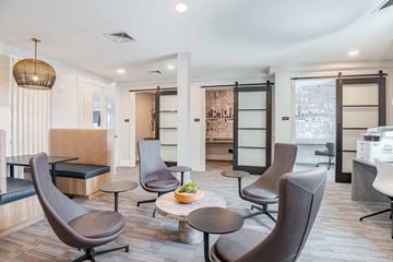 Richmond apartment for rent - A modern living room with brown chairs and a wooden table.