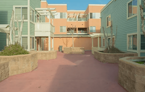 Oakland apartment for rent - A courtyard surrounded by buildings with a pinkish ground.