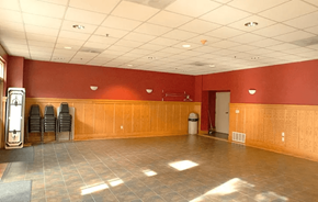 Oakland apartment for rent - A large room with wooden walls and a clock on the left side.