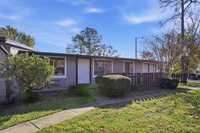 Orlando apartment for rent - A house with a grey facade and a green lawn in front.