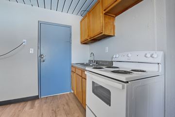 Carbondale apartment for rent - A kitchen with a white stove top oven and a blue door.